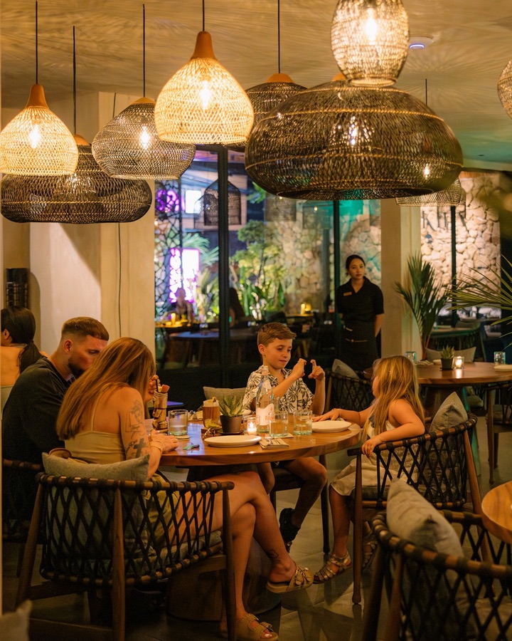 Friends sharing a candle-lit dinner at Té Kila